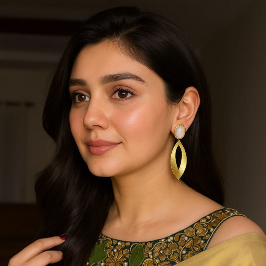 Woman wearing a yellow saree with green embroidery, posing indoors.